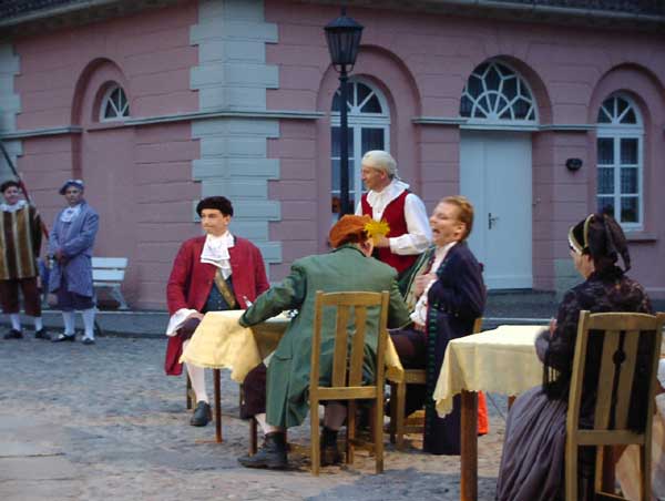 Fokko von Langen (Frederik Mampe) und Salverius von Brügge (Lutz Bode) sind allgegenwärtig und bekommen mit, wie sich Junker Christoph (Ole Lambrecht) von den ostfriesischen Gesandten Eggerik Beninga (Horst Karstens) und dem Offizier (Marc Gelhart) provozieren lassen muss. Auch der Mundschenk (Harald Schmidt) zwischen den beiden lacht - noch... Christophs älteste Schwester Froichen Anna (Frauke Unruh-Ludwig) muss schlichtend eingreifen.